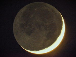 Earthshine or Da Vinci Light visible on the waxing crescent moon through a telescope